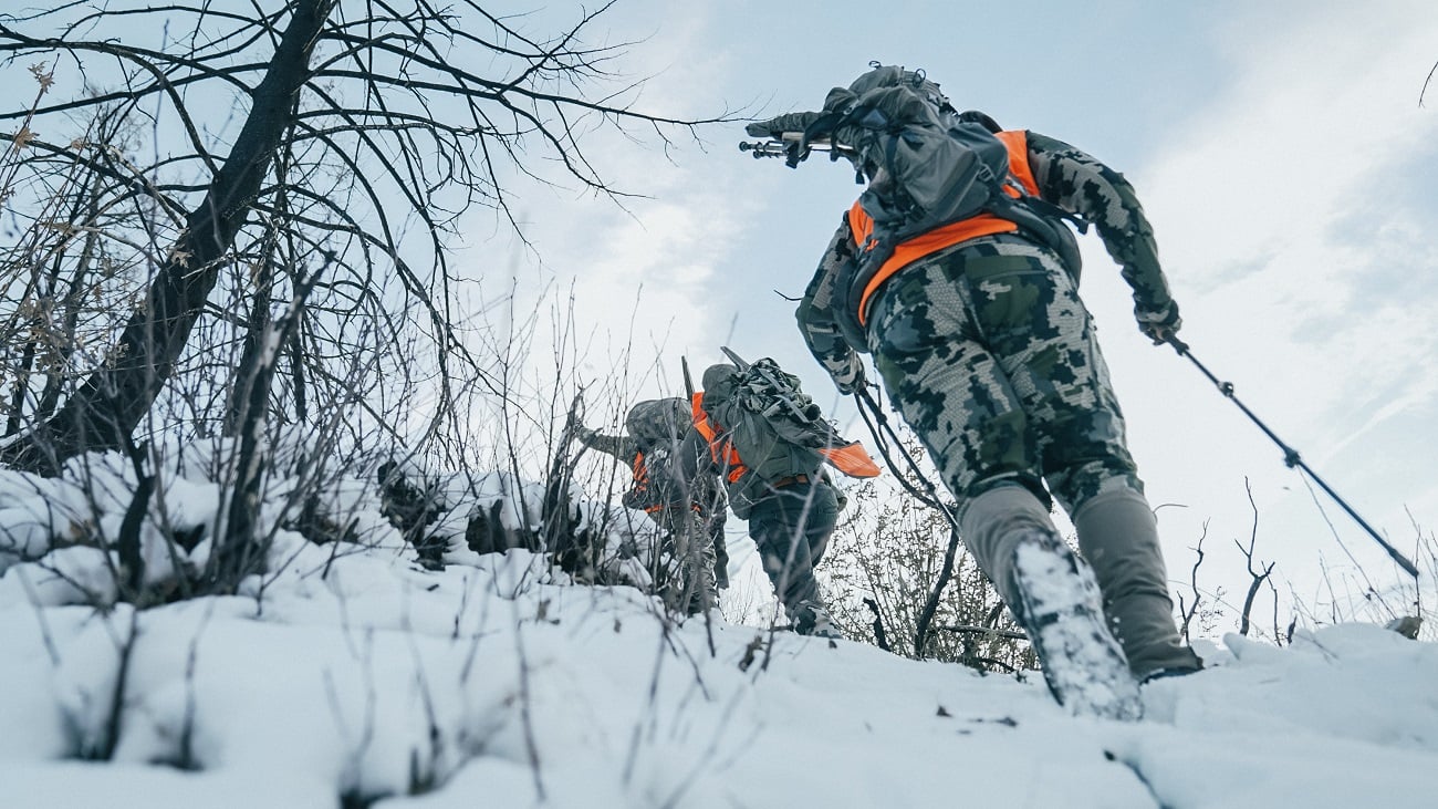 Layered winter hunting clothes with a base layer, mid layer, and outer shell help hunters stay warm while hunting.